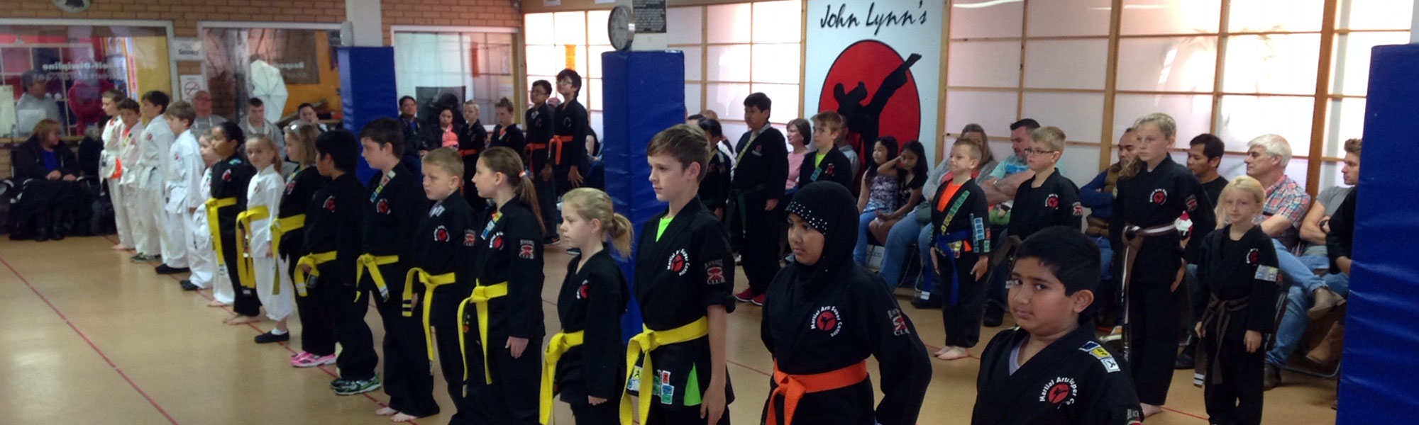 Students standing in John Lynn’s Black Belt Academy karate class using merit badges system